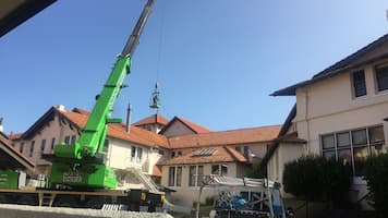 Roof Cleaning a Concrete Roof from a crane cage
